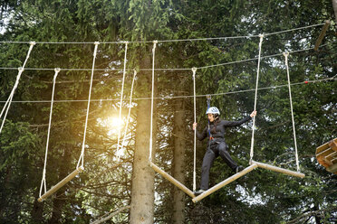 Teenage girl on high rope course - CUF11489