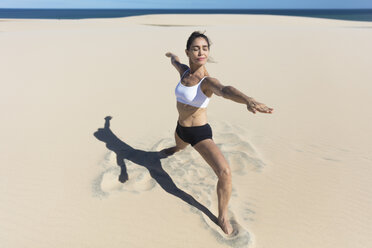 Frau am Strand Arme öffnen Stretching in Yoga-Position - CUF11526