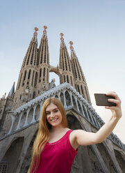 Woman taking selfie infront of Sagrada familia cathedral, Barcelona, Catalonia, Spain, Europe - CUF11530