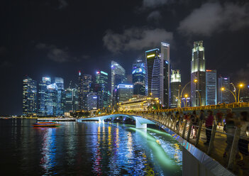 Touristenmassen auf der Brücke am Ufer der Marina Bay bei Nacht, Singapur, Südostasien - CUF11603