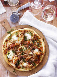 Roast pork and apple pizza on serving board, elevated view - CUF11635