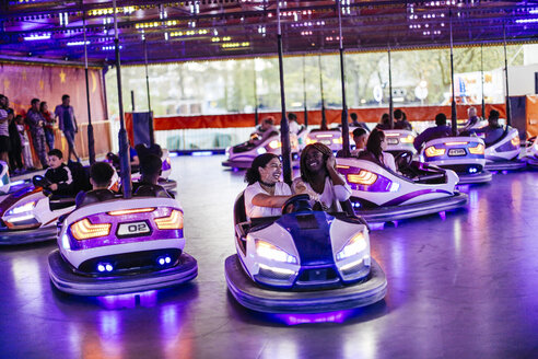 Gruppe von Freunden auf der Kirmes, die Autoscooter fahren - CUF11793