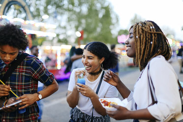 Group of friends at funfair, boy looking at smartphone - CUF11794