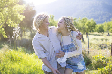 Young couple laughing while strolling in rural field, Majorca, Spain - CUF11799