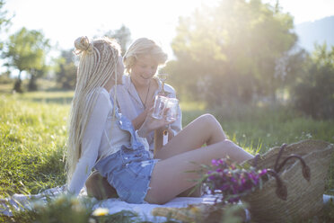 Junges Paar auf Picknickdecke im Feld mit Weinflasche und Gläsern, Mallorca, Spanien - CUF11808