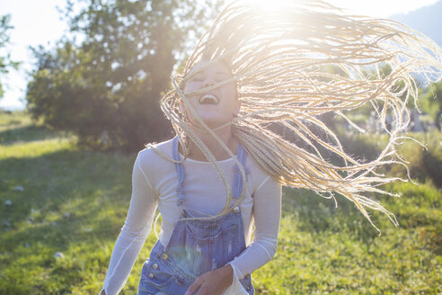 Fröhliche junge Frau mit langen geflochtenen blonden Haaren auf einem Feld, Mallorca, Spanien - CUF11810
