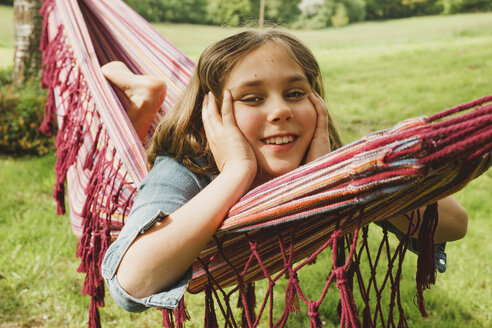 Porträt eines lächelnden Mädchens, das sich in einer Hängematte entspannt - ANHF00044