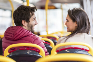 Großbritannien, London, glückliches junges Paar sitzt nebeneinander im Bus - WPEF00267