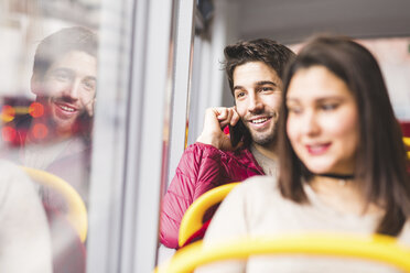 UK, London, Porträt eines lächelnden jungen Mannes, der in einem Bus telefoniert - WPEF00271