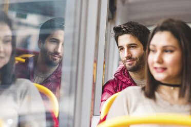 Großbritannien, London, Porträt eines lächelnden jungen Mannes im Bus, der aus dem Fenster schaut - WPEF00272