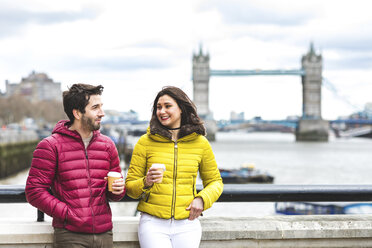 UK, London, Paar mit Kaffee zum Mitnehmen auf einer Brücke über die Themse stehend - WPEF00284