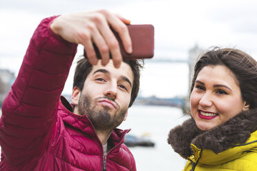 UK, London, Porträt eines jungen Paares, das ein Selfie mit einem Smartphone macht - WPEF00286