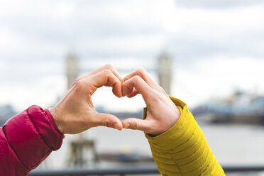 UK, London, hands of young couple in love forming heart, close-up - WPEF00289