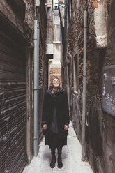 Junge Frau blickt von einer Gasse auf, Venedig, Italien - CUF11925