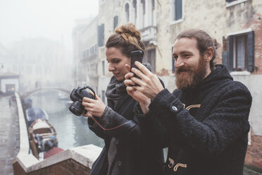 Pärchen beim Fotografieren am nebligen Kanalufer, Venedig, Italien - CUF11929