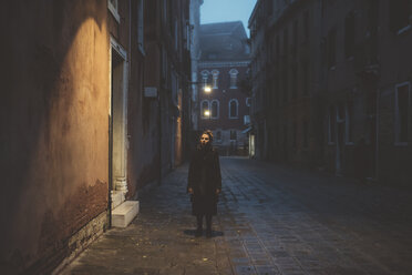 Porträt einer jungen Frau auf der Straße in der Abenddämmerung, Venedig, Italien - CUF11934