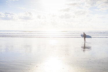 Distant view of woman carrying surfboard on beach, Nosara, Guanacaste Province, Costa Rica - CUF11953