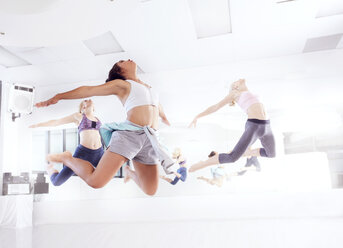 Junge Balletttänzerinnen üben im Tanzstudio und springen im Gleichschritt - CUF11970