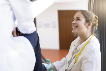 Ärztinnen machen eine Pause im Treppenhaus eines Krankenhauses und unterhalten sich - CUF12001