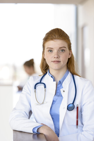 Porträt einer rothaarigen jungen Ärztin im Krankenhaus, lizenzfreies Stockfoto