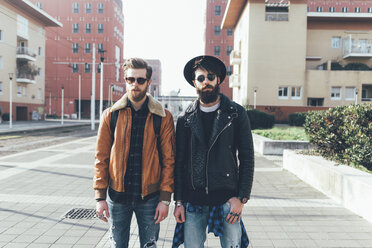 Portrait of two young male hipster friends standing in city housing estate - CUF12026