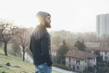 Young male hipster looking out over cityscape - CUF12042