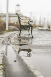 Empty bench feflecting in puddle on a rainy day - AFVF00488