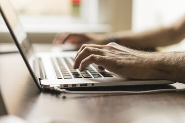 Männliche Hand auf der Tastatur eines Laptops, Teilansicht - AFVF00496