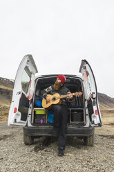 Island, Mann vor Lieferwagen spielt Gitarre - AFVF00504