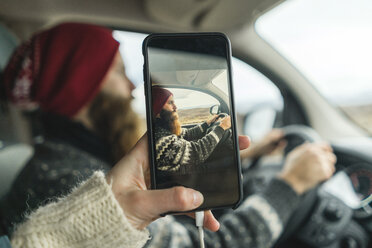 Iceland, woman taking photo of her boyfriend driving van - AFVF00511