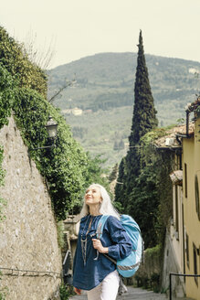 Ältere Frau schaut von einer gepflasterten Straße auf, Fiesole, Toskana, Italien - CUF12082