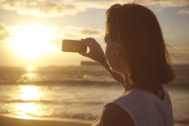 Young woman on beach, photographing view, Schotsche kloof, Western Cape, South Africa, Africa - CUF12151