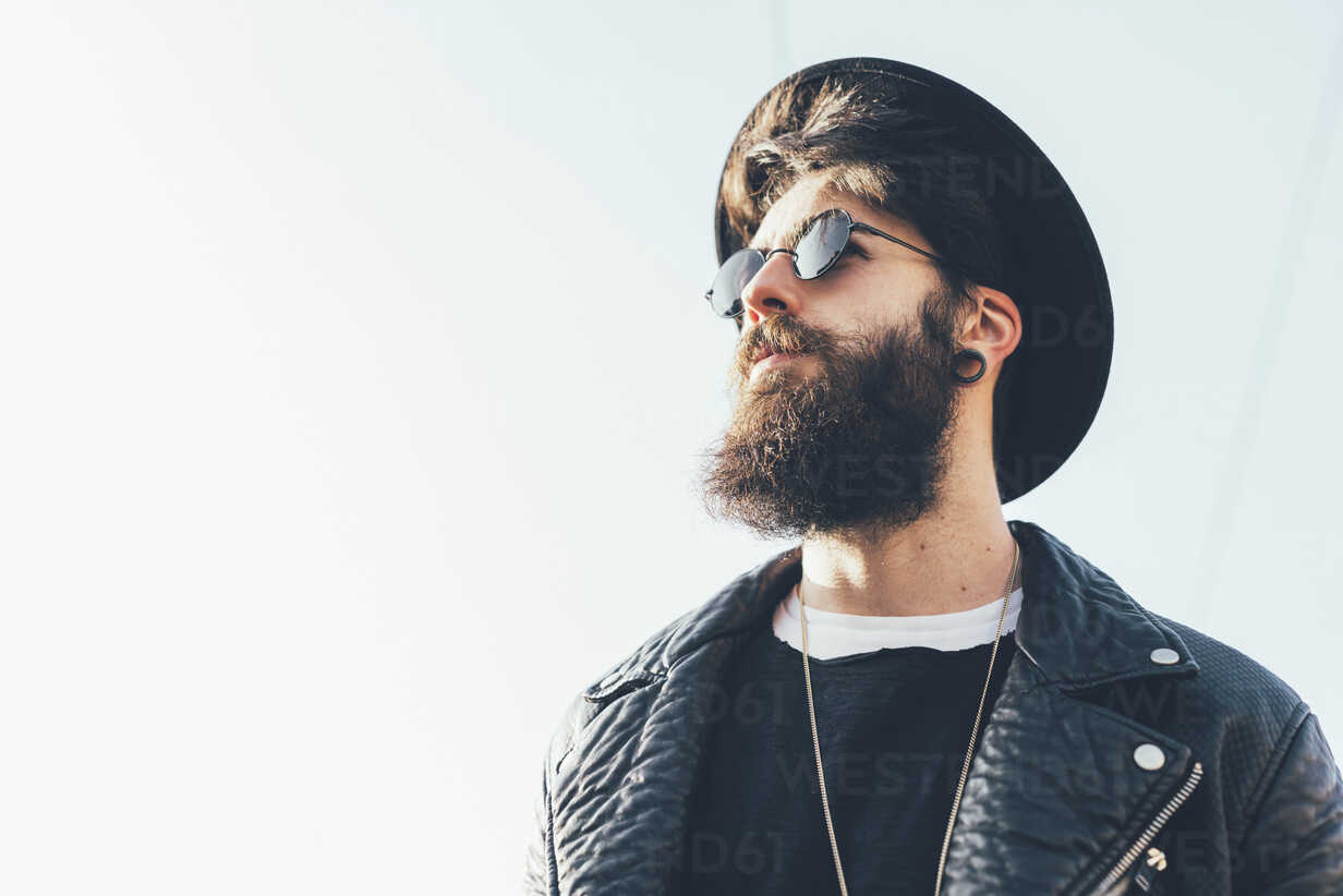 Happy hipster man with beard and sunglasses typing message and walking in  the countryside | Hipster man, Stylish leather jacket, Fashion