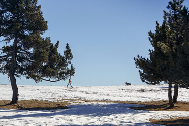 Man walking dog in snow covered horizon - CUF12211
