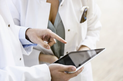 Zwei Ärzte schauen auf ein digitales Tablet, Mittelteil, Nahaufnahme - CUF12224