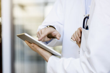 Zwei Ärzte schauen auf ein digitales Tablet, Mittelteil, Nahaufnahme - CUF12225