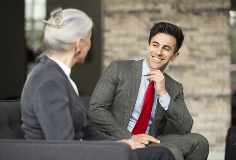 Geschäftsmann und Frau bei einem Treffen auf dem Bürosofa, lizenzfreies Stockfoto