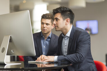 Zwei Geschäftsleute schauen auf einen Bürocomputer - CUF12298