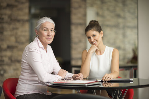 Porträt von zwei Geschäftsfrauen am Bürotisch, lizenzfreies Stockfoto