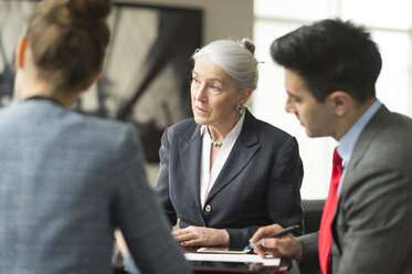 Businessman discussing with female colleagues in boardroom meeting - CUF12345