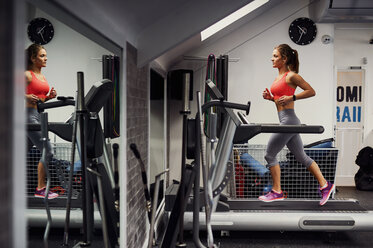 Young woman training, running on gym treadmill - CUF12502