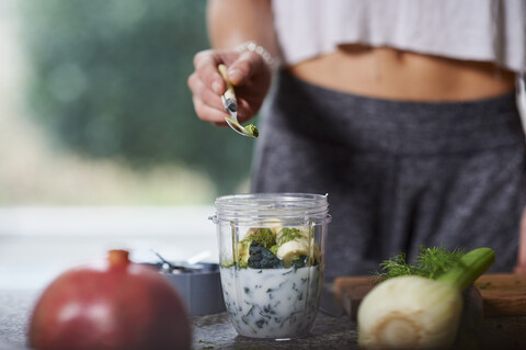 Young woman preparing smoothie stock photo