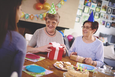 Daughter talking to mother and friend at birthday party - CUF12587