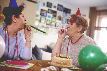 Ältere Frauen, die sich gegenseitig mit Partygeschenken bewerfen - CUF12589