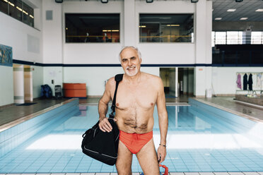 Älterer Mann trägt Tasche am Schwimmbad - CUF12784
