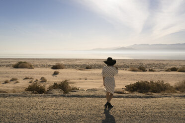 Rückansicht einer Frau mit Sonnenhut, die in die Wüste schaut, Salton Sea, Kalifornien, USA - ISF02110