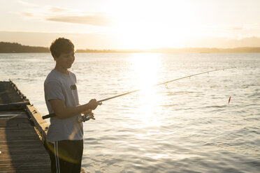 Teenage boy fishing, Pacific Rim National Park, Vancouver Island, Canada - ISF02116
