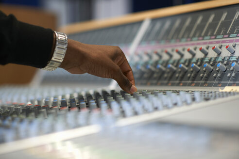 Hand eines männlichen Studenten am Tonmischpult im Aufnahmestudio - CUF12829