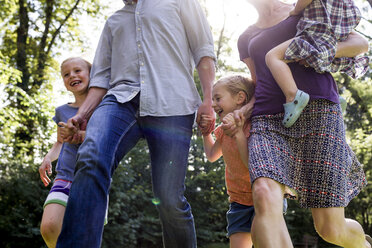 Ausgeschnittene Aufnahme von Eltern und drei kleinen Töchtern, die im Park laufen - CUF12950