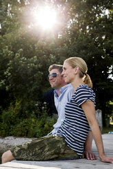 Couple sitting on wooden pier at lakeside - CUF12957